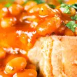 Close-up Indian-inspired spicy masala baked beans on toast with fresh coriander.