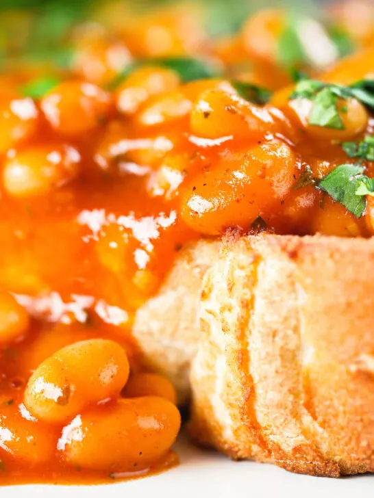 Close-up Indian-inspired spicy masala baked beans on toast with fresh coriander.