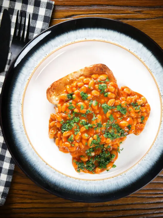 Overhead Indian-inspired spicy masala baked beans on toast with fresh coriander.