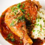 Close-up poulet au vinaigre, chicken legs in garlic and vinegar served with celeriac mash.