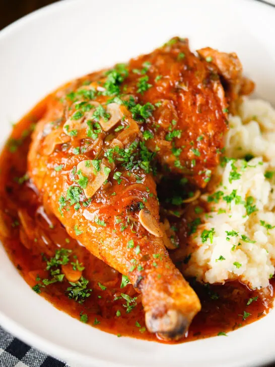 Close-up poulet au vinaigre, chicken legs in garlic and vinegar served with celeriac mash.