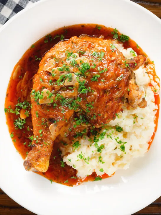 Overhead close-up poulet au vinaigre, chicken legs in garlic and vinegar served with celeriac mash.