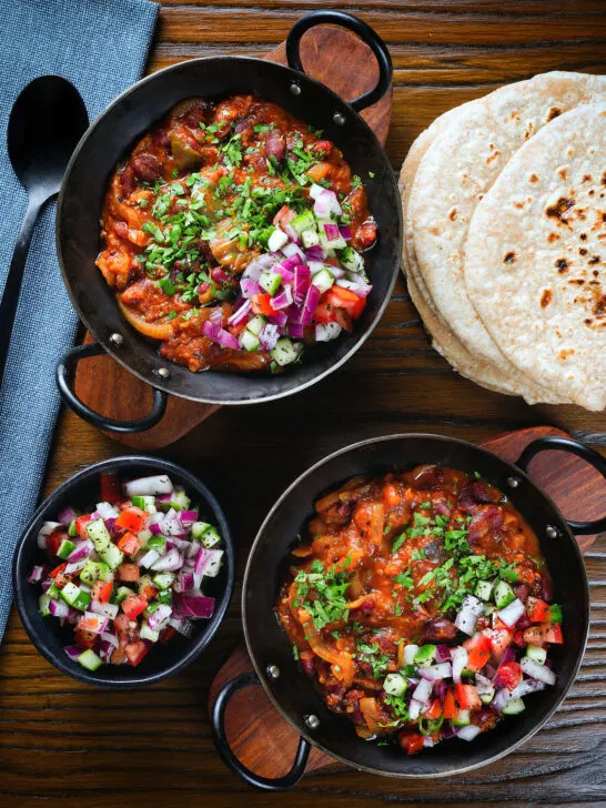 Overhead rajma masala (kidney bean curry) served with kachumber salad and homemade chapatis.