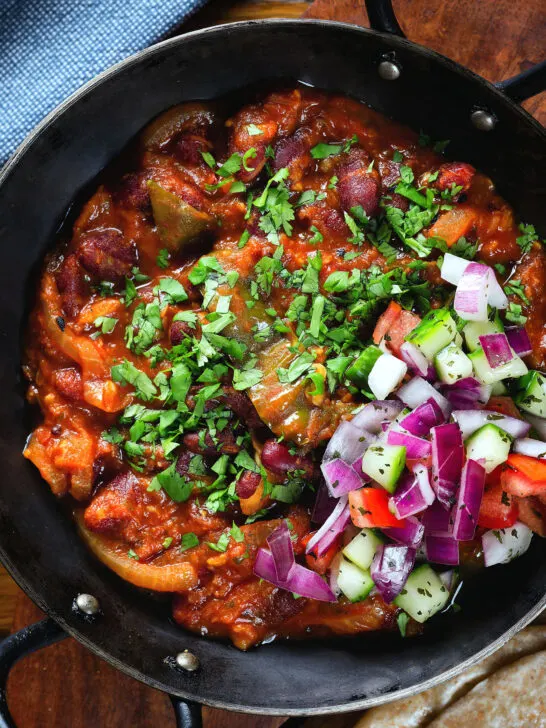 Overhead close-up rajma masala (kidney bean curry) served with kachumber salad.