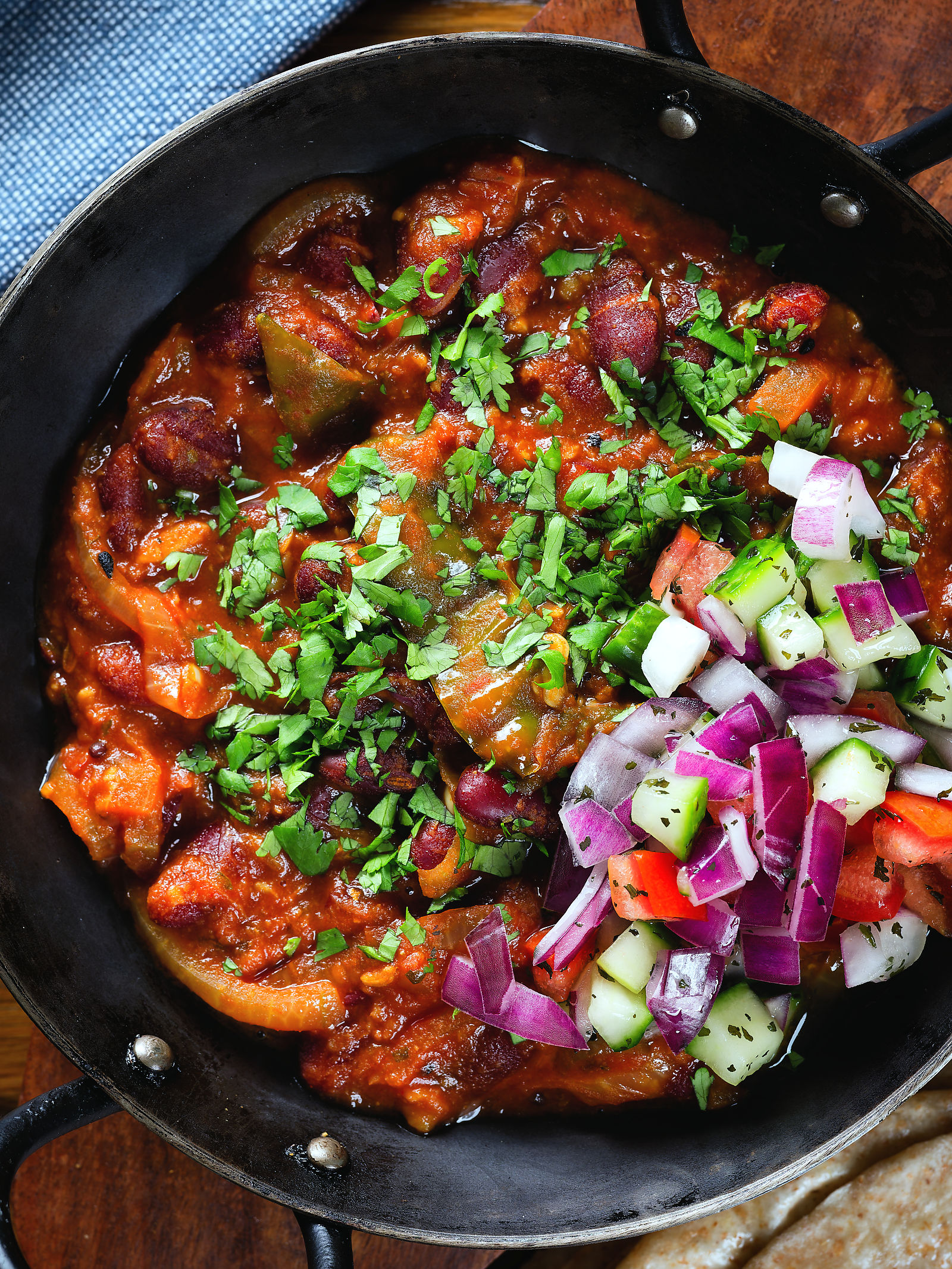 Overhead close-up rajma masala (kidney bean curry) served with kachumber salad.