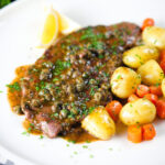 Rose veal scallopini with lemon and capers (piccata) served with buttered potatoes and carrots.