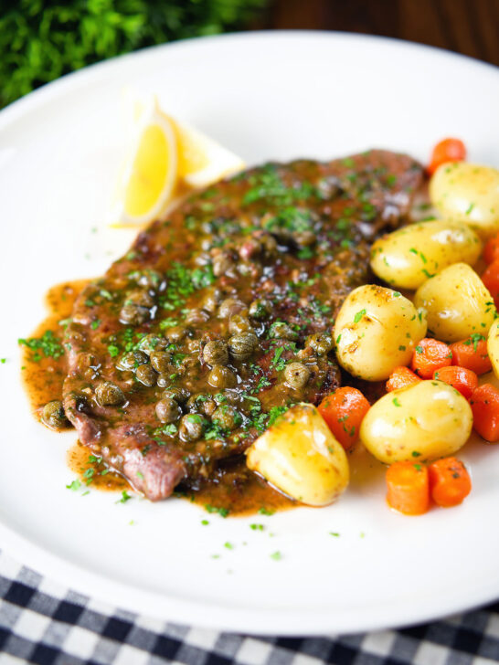 Rose veal scallopini with lemon and capers (piccata) served with buttered potatoes and carrots.