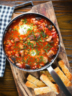 Overhead sausage, bacon, black pudding and baked bean breakfast casserole with toast.