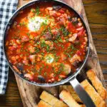 Overhead sausage, bacon, black pudding and baked bean breakfast casserole with toast.
