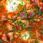 Overhead close-up sausage, bacon, black pudding and baked bean breakfast casserole.