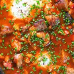 Overhead close-up sausage, bacon, black pudding and baked bean breakfast casserole.