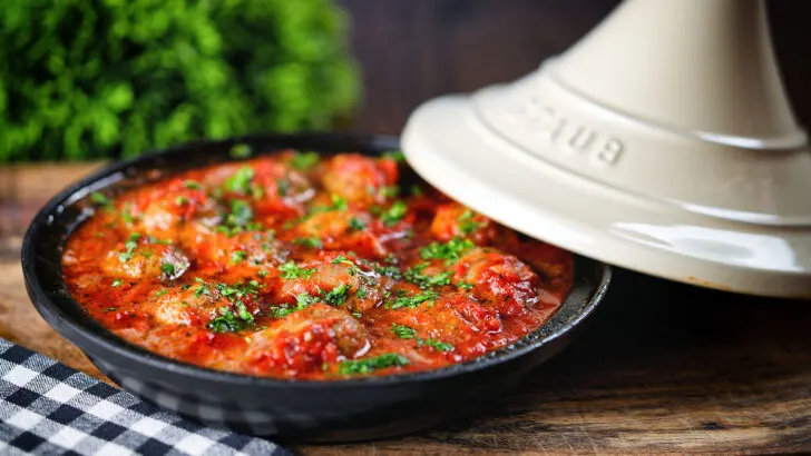 Spicy Moroccan-influenced lamb meatball tagine garnished with chopped parsley.