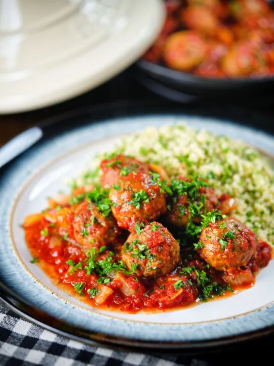 Spicy Moroccan-influenced lamb (kefta) meatball tagine served with herby buttered couscous.