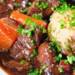 Close-up rich red wine and port venison stew or casserole with suet dumplings.