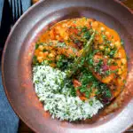 Overhead vegetarian chickpea and parsnip curry served with coriander rice.