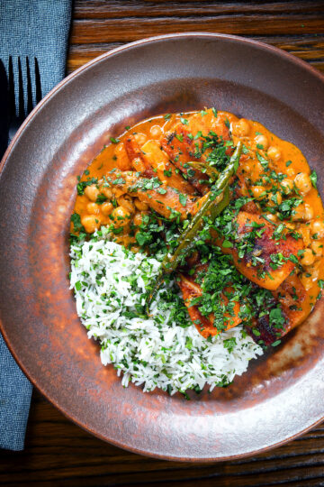 Overhead vegetarian chickpea and parsnip curry served with coriander rice.
