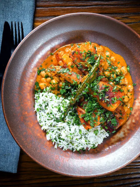Overhead vegetarian chickpea and parsnip curry served with coriander rice.
