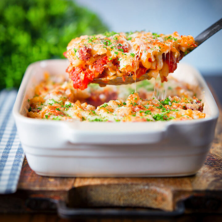 Tinned corned beef and tomato macaroni pasta bake being served with a spoon.