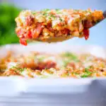 Corned beef and tomato macaroni pasta bake being served with a spoon.