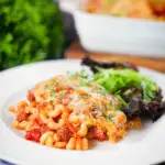 Corned beef and tomato macaroni pasta bake served with a side salad.