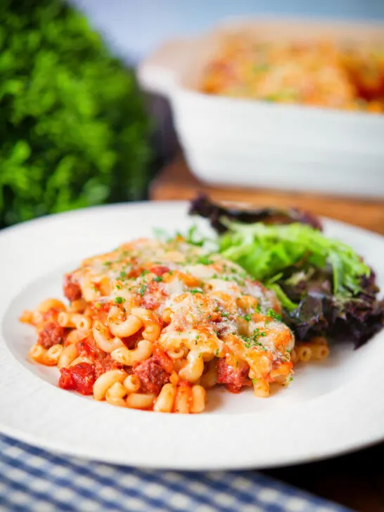 Corned beef and tomato macaroni pasta bake served with a side salad.