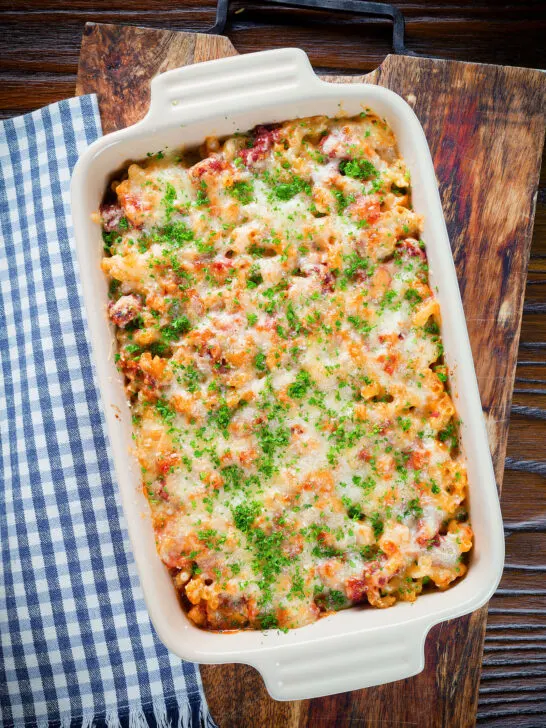 Overhead corned beef and tomato macaroni pasta bake with a cheesy topping.