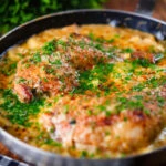 Close-up Somerset chicken cooked in a cider, cheddar cheese and cream sauce served in a pan.
