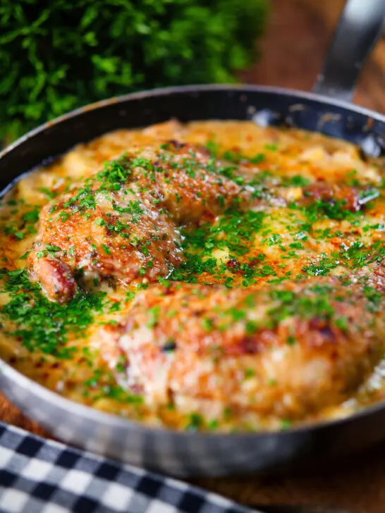 Close-up Somerset chicken cooked in a cider, cheddar cheese and cream sauce served in a pan.