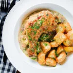 Overhead Somerset chicken legs in a creamy cider and cheddar sauce served with mini roast potatoes.