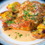 Dijon chicken leg or poulet Gaston Gerard served with roasted crushed new potatoes.