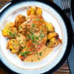 Overhead Dijon chicken leg or poulet Gaston Gerard served with roasted crushed new potatoes.