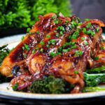 Close-up honey and mustard glazed sausages with mashed potato and tenderstem broccoli.