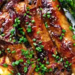 Close-up overhead honey and mustard glazed sausages with mashed potato and tenderstem broccoli.