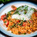 Oven roasted hake with cherry tomatoes and capers served with pourgori.