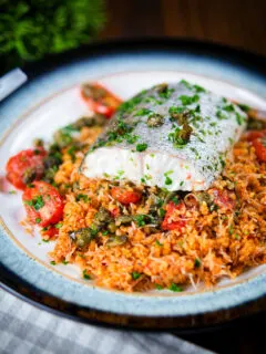 Oven roasted hake with cherry tomatoes and capers served with pourgori.