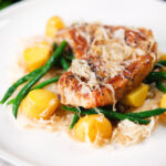 Slow cooker pork chops and sauerkraut with potatoes and green beans.