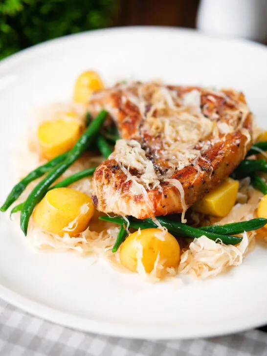 Slow cooker pork chops and sauerkraut with potatoes and green beans.
