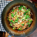 Overhead vegetarian ho fun (ho fan) noodles stir fry in a wok.