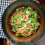 Overhead vegetarian ho fun (ho fan) noodles stir fry in a wok.