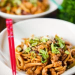 Stir fried teriyaki chicken noodles with spring onions and sesame seeds.