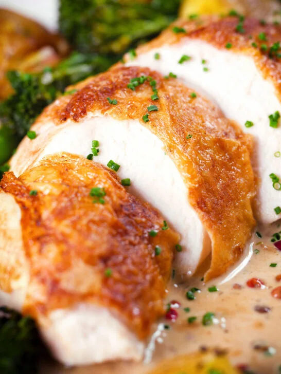 Close-up chicken breast (roasted on the crown) in peppercorn sauce.