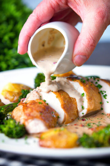 Roasted chicken breast with in peppercorn sauce with extra sauce poured over with broccoli and potatoes.