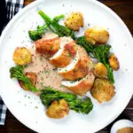 Overhead chicken breast (roasted on the crown) in peppercorn sauce, smashed potatoes and broccoli.