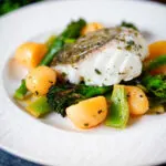 Cod traybake with potatoes, broccoli and runner beans cooked in a herby olive oil.