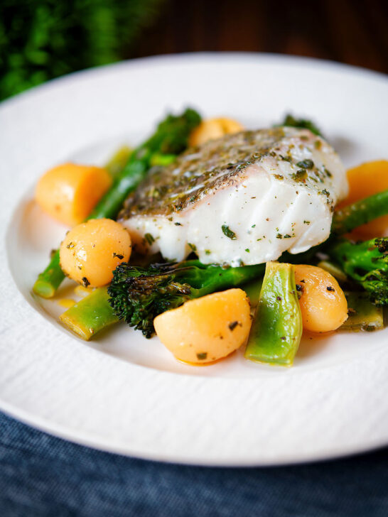 Cod traybake with potatoes, broccoli and runner beans cooked in a herby olive oil.