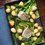 Overhead cod traybake with potatoes, broccoli and runner beans on a sheet pan.