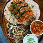 Overhead paneer tikka kebabs served with chapatis, onion salad, raita and mango chutney.