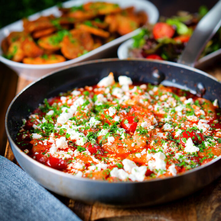 Greek-inspired prawn (shrimp) saganaki with feta cheese served with potatoes and salad.