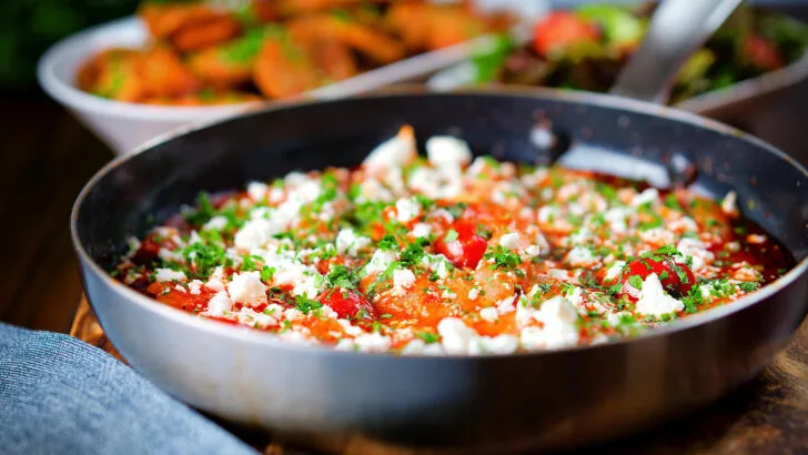 Greek-inspired prawn (shrimp) saganaki with feta cheese served with potatoes and salad.