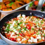 Greek prawn (shrimp) saganaki with feta cheese served with potatoes and salad.